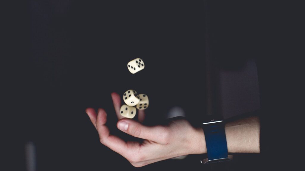 A hand tossing dice, illustrating a random outcome