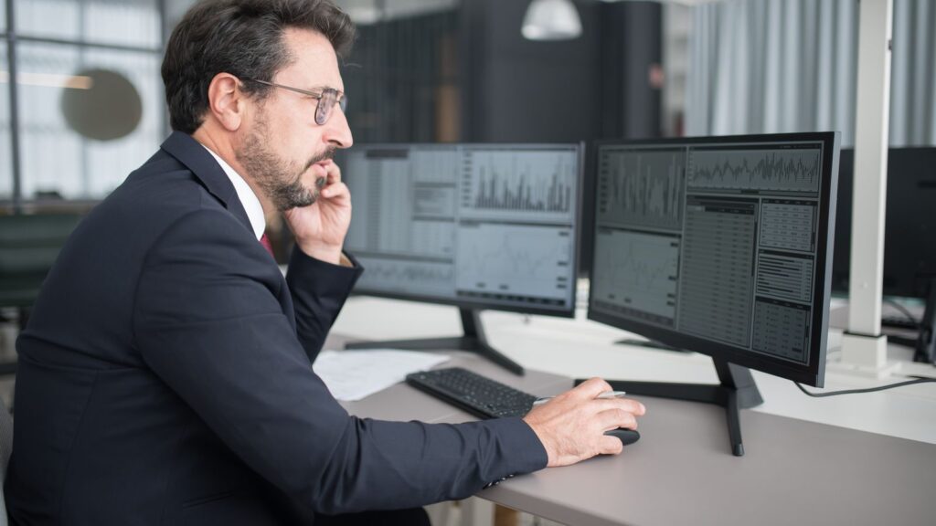 Analyst comparing results side by side on two monitors
