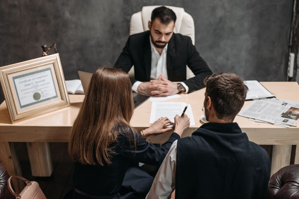 Lawyer meeting two clients across a desk in a law office