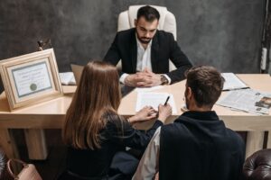 Lawyer meeting two clients across a desk in a law office
