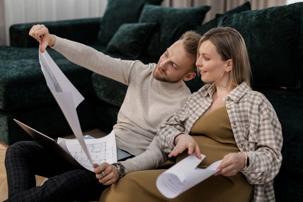 Couple sitting on a sofa looking over floor plans, the buyer a home builder landing page is written for