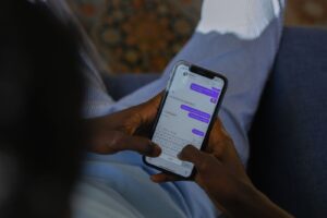 Person holding a smartphone and typing a message into a chat app