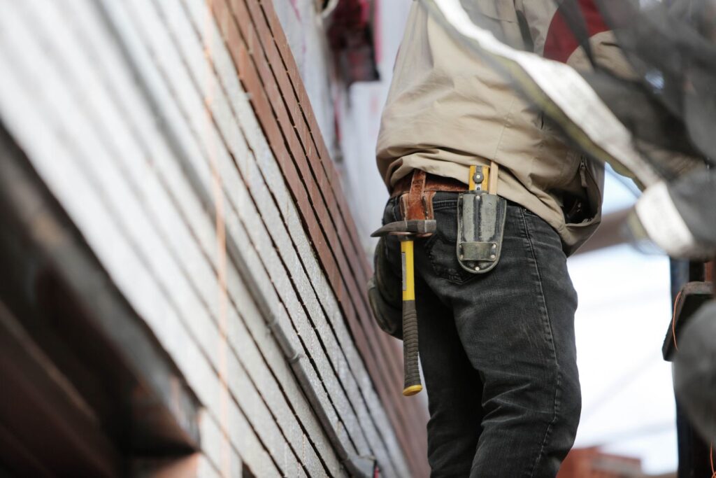 Builder on a residential construction site with a hammer and tools on his belt