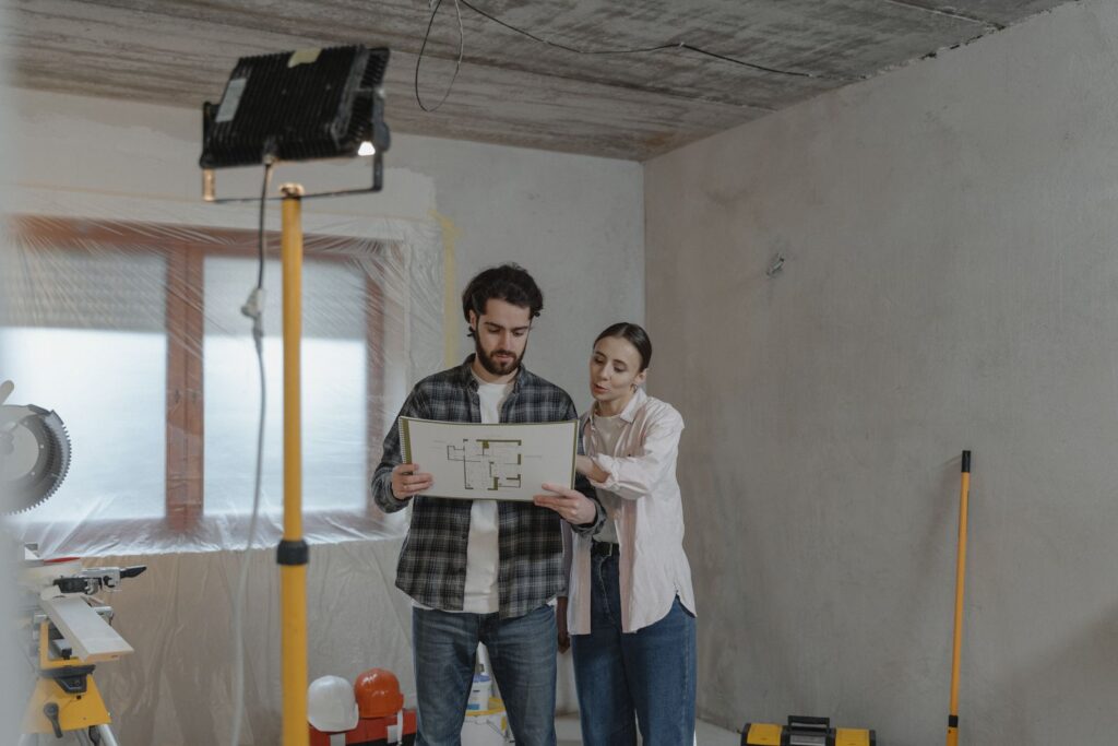 Couple reviewing floor plans in a room being renovated, the kind of buyer builder marketing needs to reach