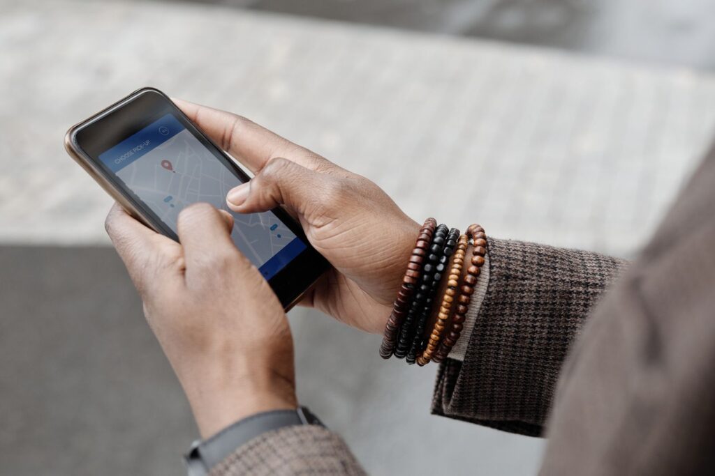 Hands holding a smartphone with a map and location pin open, searching for a local business