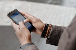 Hands holding a smartphone with a map and location pin open, searching for a local business