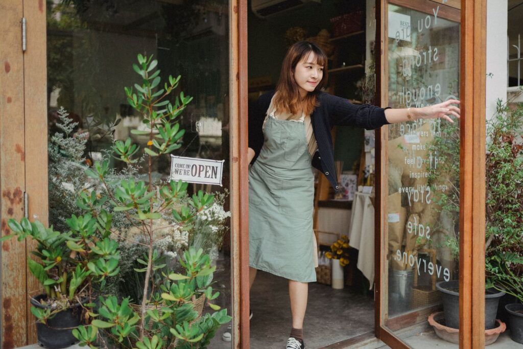 Shop owner opening the glass door of her store, the kind of real storefront a Google Business Profile should match