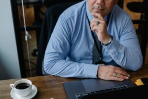 Business owner at a laptop thinking about how AI assistants describe his business